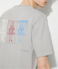Person wearing a gray t-shirt with brand logos CP Company on the back against a white background