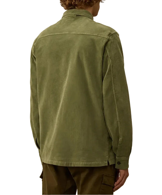 Person wearing a green jacket against a beige background