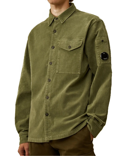 Person wearing a green CP Company Shirt with a brand patch on a white background