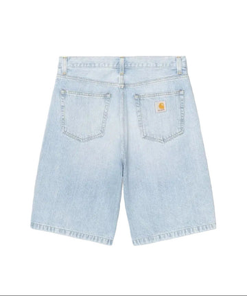Light wash blue denim shorts shown from the back, featuring two back pockets with a small yellow Carhartt logo patch on the right pocket, set against a plain white background.