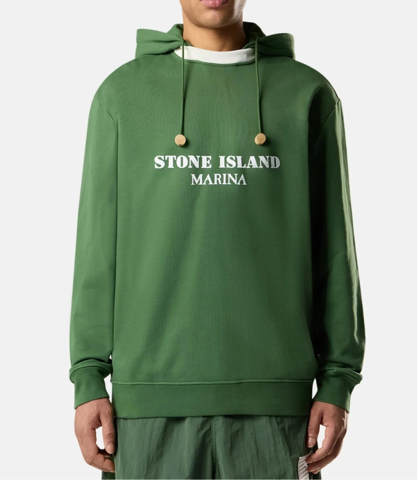 Person wearing a green Stone Island hoodie on a white background