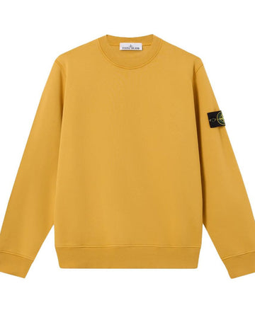 A yellow crewneck sweatshirt with a Stone Island compass patch on the left sleeve, displayed against a plain white background.