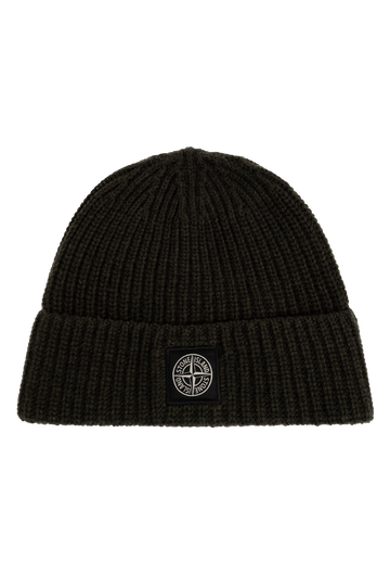 A black ribbed knit beanie hat featuring a small black square patch on the front cuff with the circular Stone Island compass logo. 