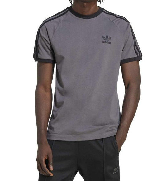 Person wearing a gray Adidas t-shirt with black trim on a white background