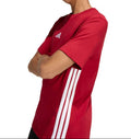 Person wearing a red Adidas t-shirt with white stripes on a white background