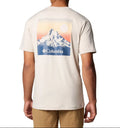 Person wearing a cream-colored t-shirt with a mountain graphic and Columbia logo on the back.