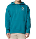 Person wearing a teal hoodie with a logo on a white background