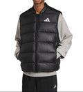 A man wearing a black Adidas puffer vest over a gray long-sleeve shirt and black Adidas pants, photographed against a plain white background.