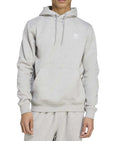 Person wearing a gray Adidas hoodie on a white background