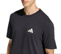 Person wearing a black Adidas t-shirt on a white background