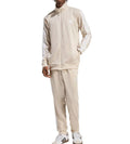 Person wearing a beige tracksuit with Adidas logo on a white background