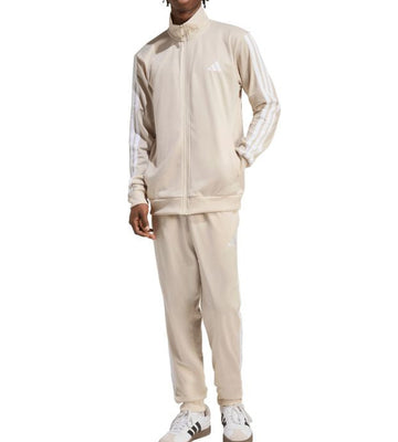 Person wearing a beige tracksuit with Adidas logo on a white background
