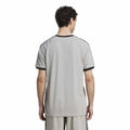 Person wearing a gray sports jersey with black trim on a white background
