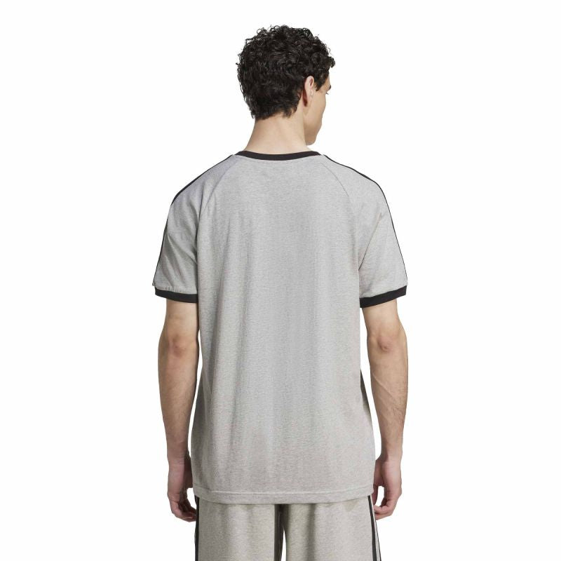 Person wearing a gray sports jersey with black trim on a white background