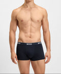 Man wearing black boxer briefs with 'BOSS' branding on a white background