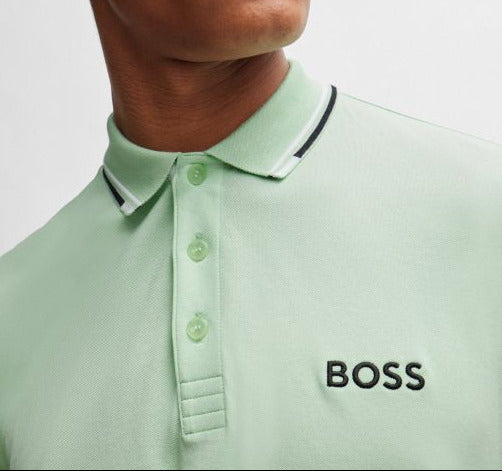 Man wearing a light green polo shirt with 'BOSS' logo and a white cap.
