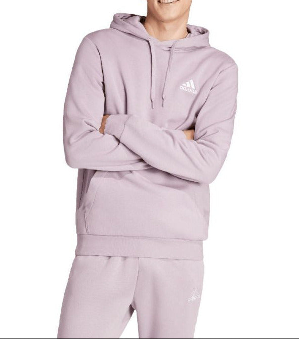 Person wearing a light purple Adidas hoodie and pants on a white background