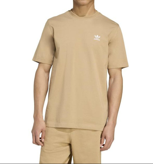 Person wearing a beige Adidas t-shirt and pants on a white background