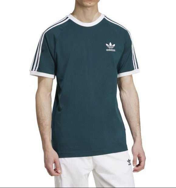 Person wearing a green Adidas t-shirt with white stripes on a white background