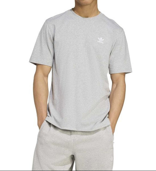 Person wearing a gray Adidas t-shirt on a white background